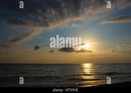 solar path on the sea on a Sunset and yellow sky with clouds Stock Photo
