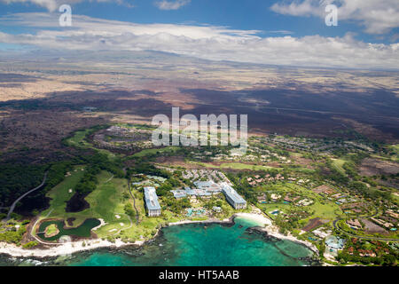 Aerial view of the luxury resort Fairmont Orchid on the west coast of Big Island, Hawaii, USA, with clouds over the summit of Mauna Kea in the back. Stock Photo