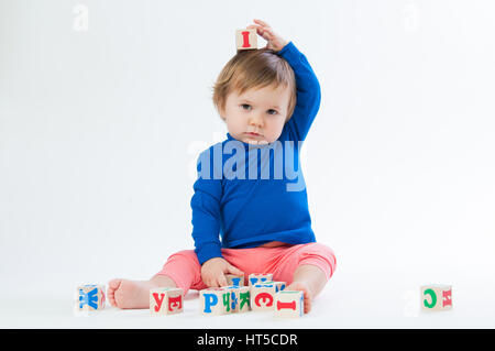 Little child playing with dices isolated on white background Stock Photo