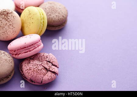 Close up of colorful macarons on purple background Stock Photo