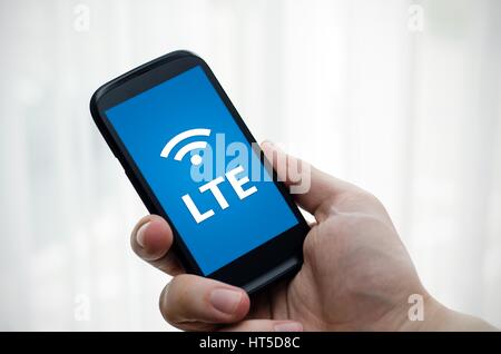 Hand holding mobile phone with LTE fast internet technology Stock Photo