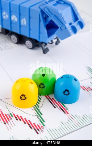 Colored trash bins and garbage truck toys on business background Stock Photo