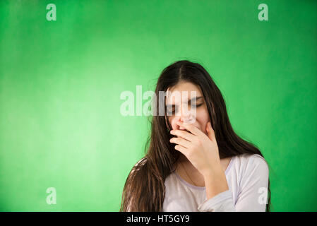 girl in her nightie wants to sleep and yawns on a green background isolated chroma key Stock Photo