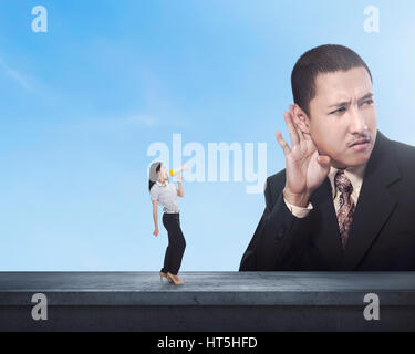 Business woman telling something to her partner using megaphone over skyline background Stock Photo