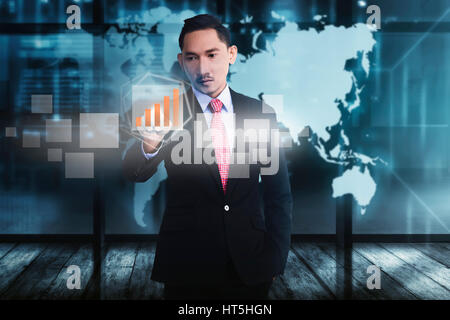 Attractive asian businessman touching digital chart with finger on virtual screen Stock Photo