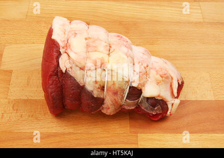 Topside beef joint on a wooden chopping board Stock Photo