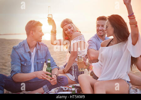 Four friends having fun at the beach party Stock Photo