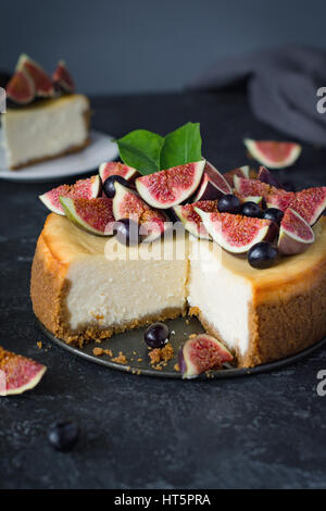 Delicious New York cheesecake with fresh figs and black grapes. Close up view. Stock Photo