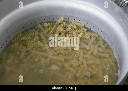 pasta called FUSILLI in Italy cooked with boiling water in large pot of Italian restaurant Stock Photo