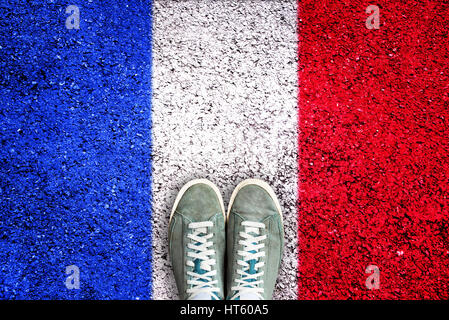 Sport shoes on asphalt with french flag, election concept Stock Photo