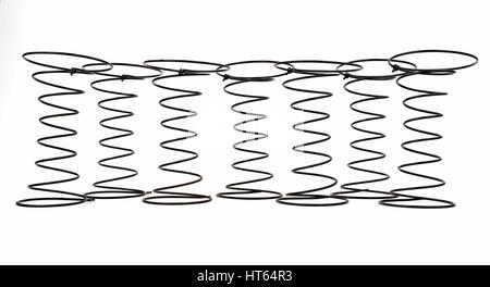 Seven Black Wire Springs used in Upholstery on white background. Stock Photo