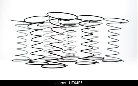 Group of Black Wire Springs used in Upholstery on white background with selective focus on the first spring. Stock Photo