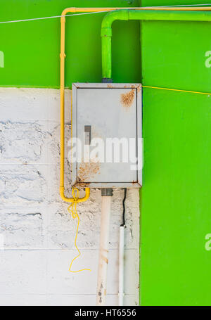 Rusty Iron Control Box on White and Green Concrete Wall Stock Photo