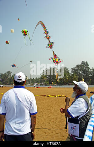 Kite flyers display kite train made of 101 small kites in single string at Goa International Kite Festival 2017 in Miramar Beach, Goa, India. Stock Photo