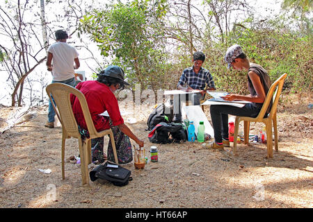 Group of young paint artists creates  paintings at a beautiful beach side garden near Siridao Beach in Goa, India. Stock Photo