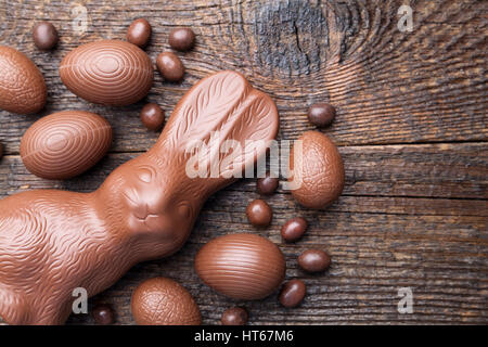 Delicious chocolate Easter bunny and eggs on wooden background Stock Photo