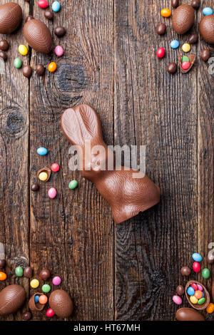 Delicious chocolate Easter bunny and eggs on wooden background Stock Photo