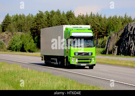 PAIMIO, FINLAND - JUNE 3, 2016: Lime green Volvo FH refrigerated transport truck hauls goods along motorway on a beautiful day of early summer. Stock Photo