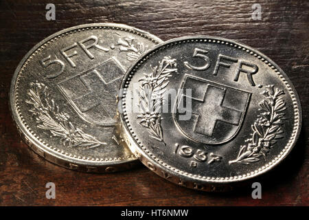 Swiss 5 FR silver coins on rustic wooden background Stock Photo