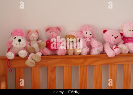 Pink Teddy bears and dolls in a newborn baby girls cot, childrens toys, kids teddies, cuddly toys, childhood concept Stock Photo