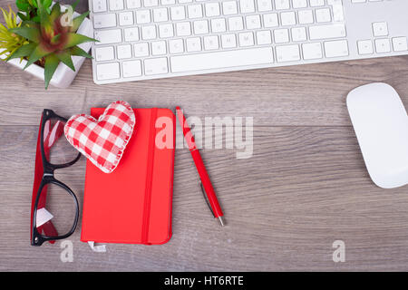 Wooden desk with a keyboard , mouse, notes and glasses  from above Stock Photo