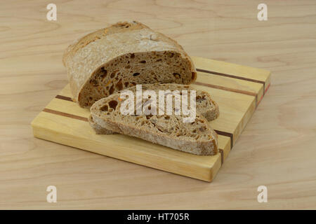 Loaf and slices of sweet potato bread on wooden cutting board Stock Photo