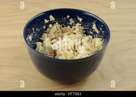 Tuna salad with chopped apple in blue bowl on table Stock Photo