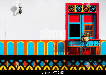 A brightly painted wooden balcony is seen in the first floor of a colonial house in Jardín, a village in the coffee region of Colombia. Stock Photo
