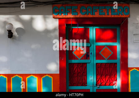 A brightly painted wooden door is seen in front of a colonial house in Jardín, a village in the coffee region (Zona cafetera) of Colombia. Stock Photo