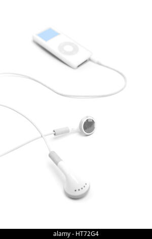 Bath, United Kingdom - March 11, 2011: Studio shot of white earbuds with an Apple iPod Nano out of focus in the background. Shot against a plain white Stock Photo