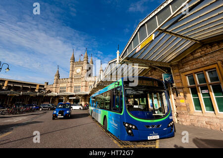 BRISTOL, UK - March 14, 2011: Exterior of Bristol Temple Meads Railway Station with a stationary Bristol Airport Shuttle Bus and passing Taxi Stock Photo