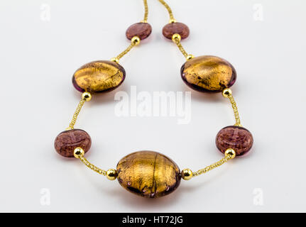 Glass - Murano gold bead and dusty rose necklace close up on white background - Venice Stock Photo