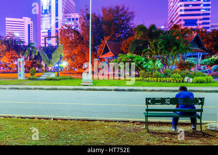 BANGKOK, THAILAND - FEBRUARY 02: This is a night view Lumphini park with a man sitting on the bench and relaxing after jogging on February 02, 2017 in Stock Photo