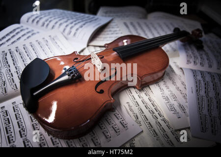 violin laying on sheets of music