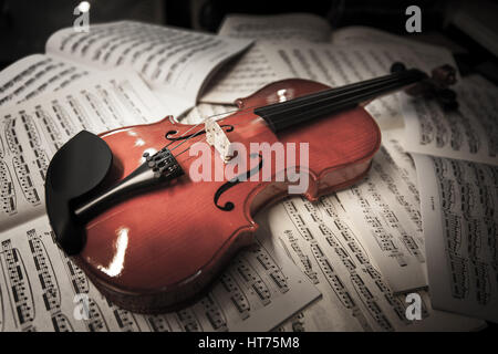 violin laying on sheets of music