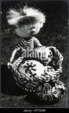 HUNGARY - CIRCA 1970: A greeting Easter postcard printed in Hungary, shows a toy with a basket of Easter eggs, circa 1970 Stock Photo