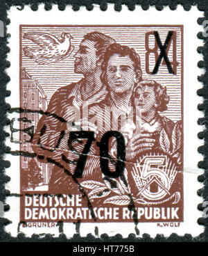 GERMANY - CIRCA 1953: A stamp printed in Germany (GDR), is dedicated to the five-year plan, shows Dove and East German family, circa 1953 Stock Photo