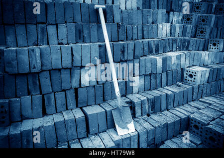 Construction site shovel and brick, blue tone image. Stock Photo