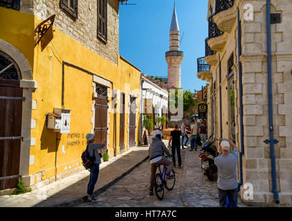 LIMASSOL, CYPRUS - April 01, 2016: Tourists walking around and shopping at shops in the narrow streets of Limassol town. Stock Photo