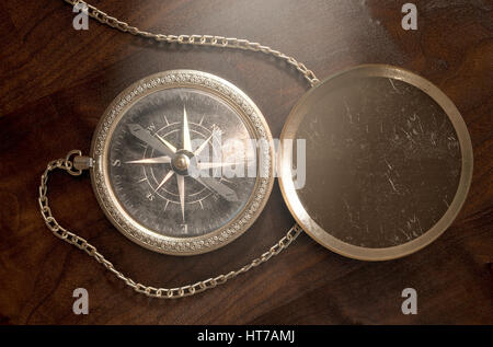 A closeup of an intricate vintage pocket compass with an open lid and a chain attached - 3D render Stock Photo