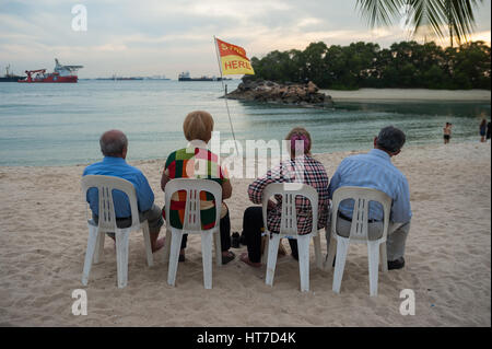 17.01.2017, Singapore, Republic of Singapore, Asia - Tourists sit at Siloso Beach on Sentosa Island. Stock Photo