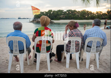 17.01.2017, Singapore, Republic of Singapore, Asia - Tourists sit at Siloso Beach on Sentosa Island. Stock Photo