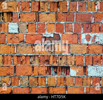 Red brick wall texture. Time dilapidated brick wall with old plaster elements Stock Photo