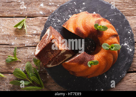 Homebaked marble bundt cake on rustic wooded table. horizontal view from above Stock Photo