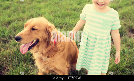 Adorable little blond girl playing with her cute pet dog Stock Photo