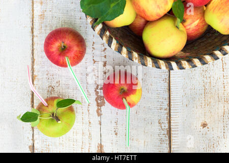 Organic apples in basket, on white vintage wooden background, healthy lifestyle concept Stock Photo
