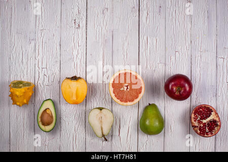 Halves of ripe fresh fruits on a wooden background. Checkerboard pattern Stock Photo