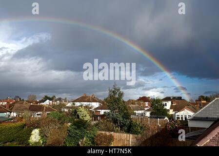 Rainbow over roofs of suburban houses Shepperton Surrey UK Stock Photo