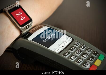 Man making payment through smartwatch via NFC contactless technology Stock Photo
