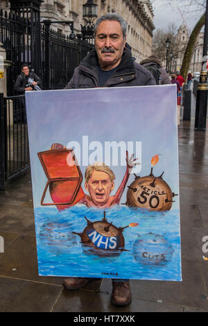 London, UK. 8th March 2017. A protest artist Kayar Mar with his latest satirical painting of Hammond struggling to stay afloat in dangerous waters - Budget day in Westminster - London 08 Mar 2017. Credit: Guy Bell/Alamy Live News Stock Photo